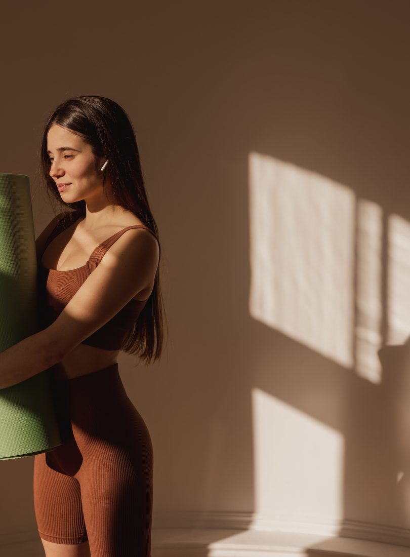 beautiful-young-caucasian-woman-sportswear-holding-yoga-mat-while-standing-indoors-darkhaired-girl-is-preparing-workout-healthy-lifestyle-keep-fit-concept